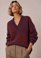 Lässiger Strickpullover mit V-Ausschnitt und modernem Streifenmuster. Weicher Strick, lockere Passform und voluminöse Ärmel – Made in Italy.