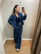 Exklusive dunkelblaue High-Waist Wide Leg Jeans aus hochwertigem Denim an Model getragen, moderner eleganter Boutique Look