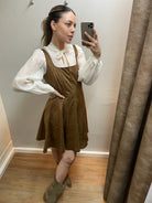 Braunes Trägerkleid mit strukturierter Oberfläche an Model getragen